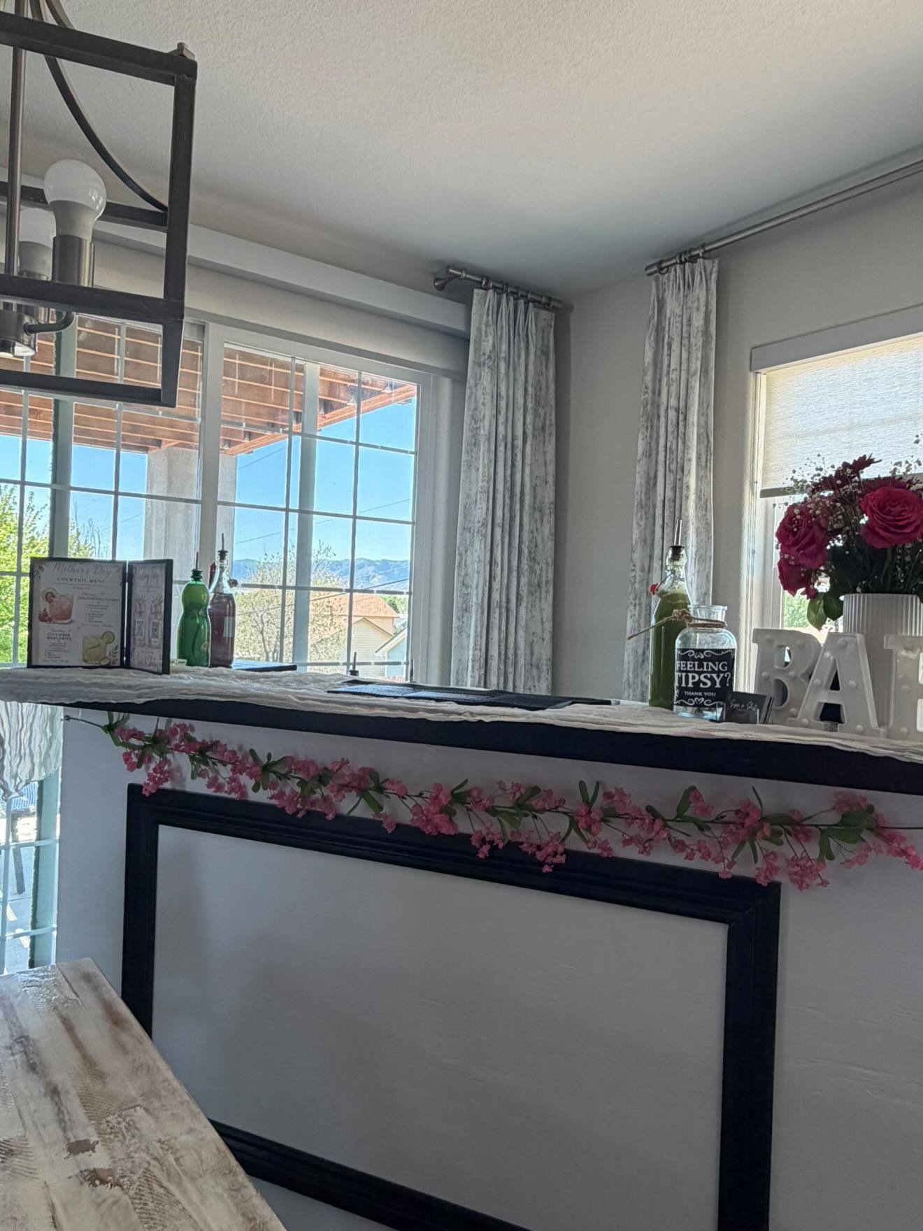 Sips & Shots bar set up indoors with floral garland