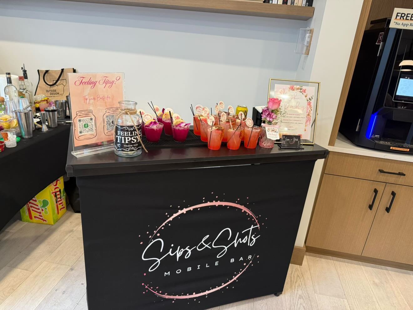 Sips & Shots bar setup with fresh flowers