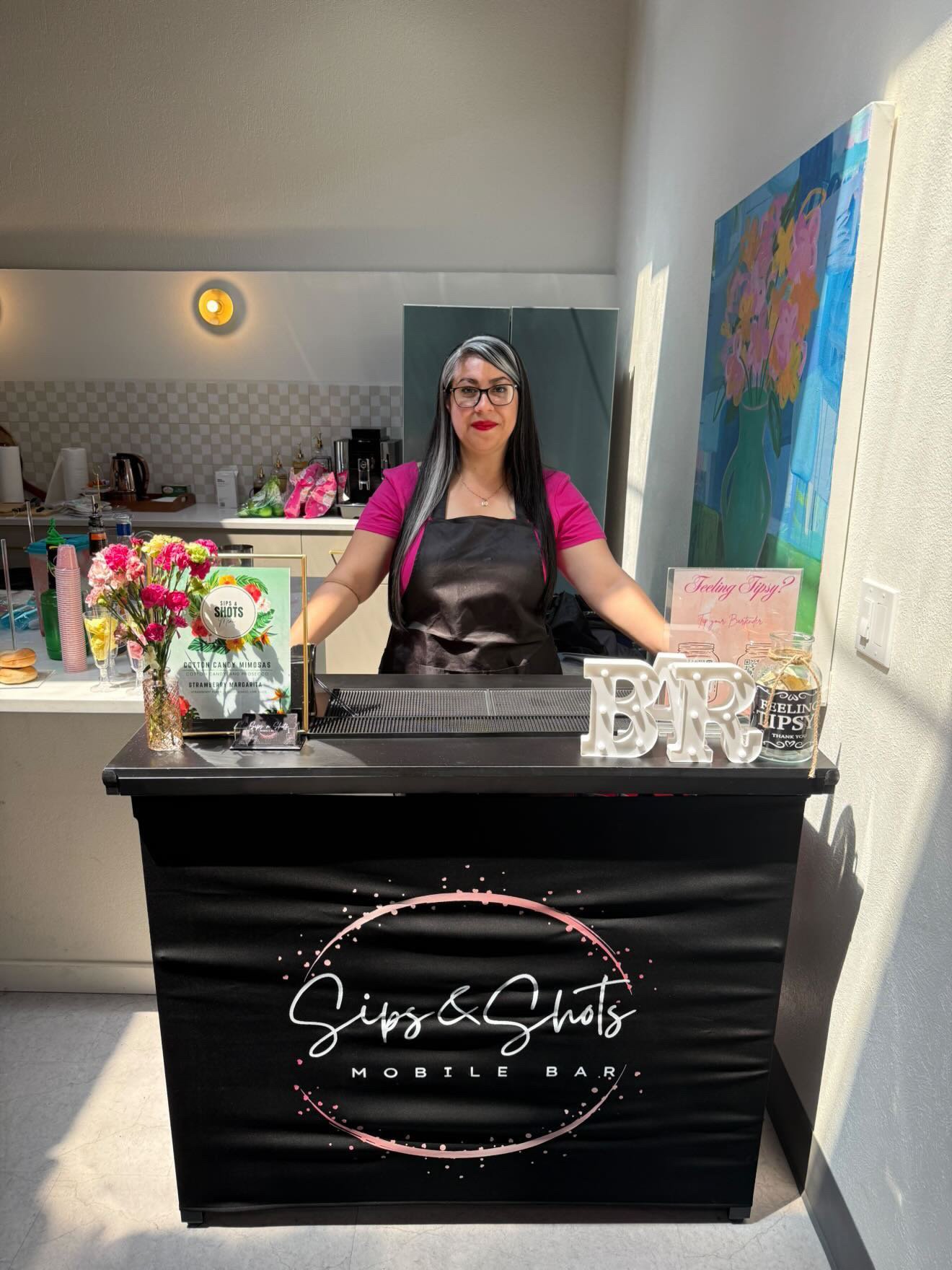 Sips & Shots bartender behind the mobile bar cart